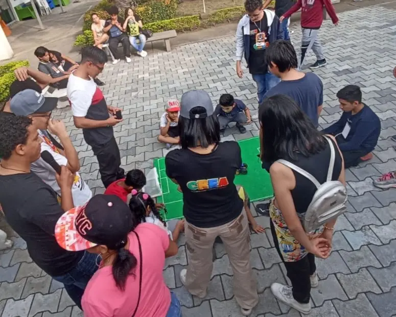 Estudiantes y visitantes del festival de robótica de CREA presenciando el torneo de fútbol de robots